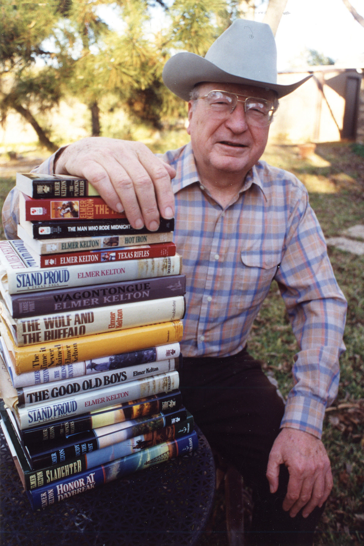 Photo of Elmer Kelton and a stack of his books.